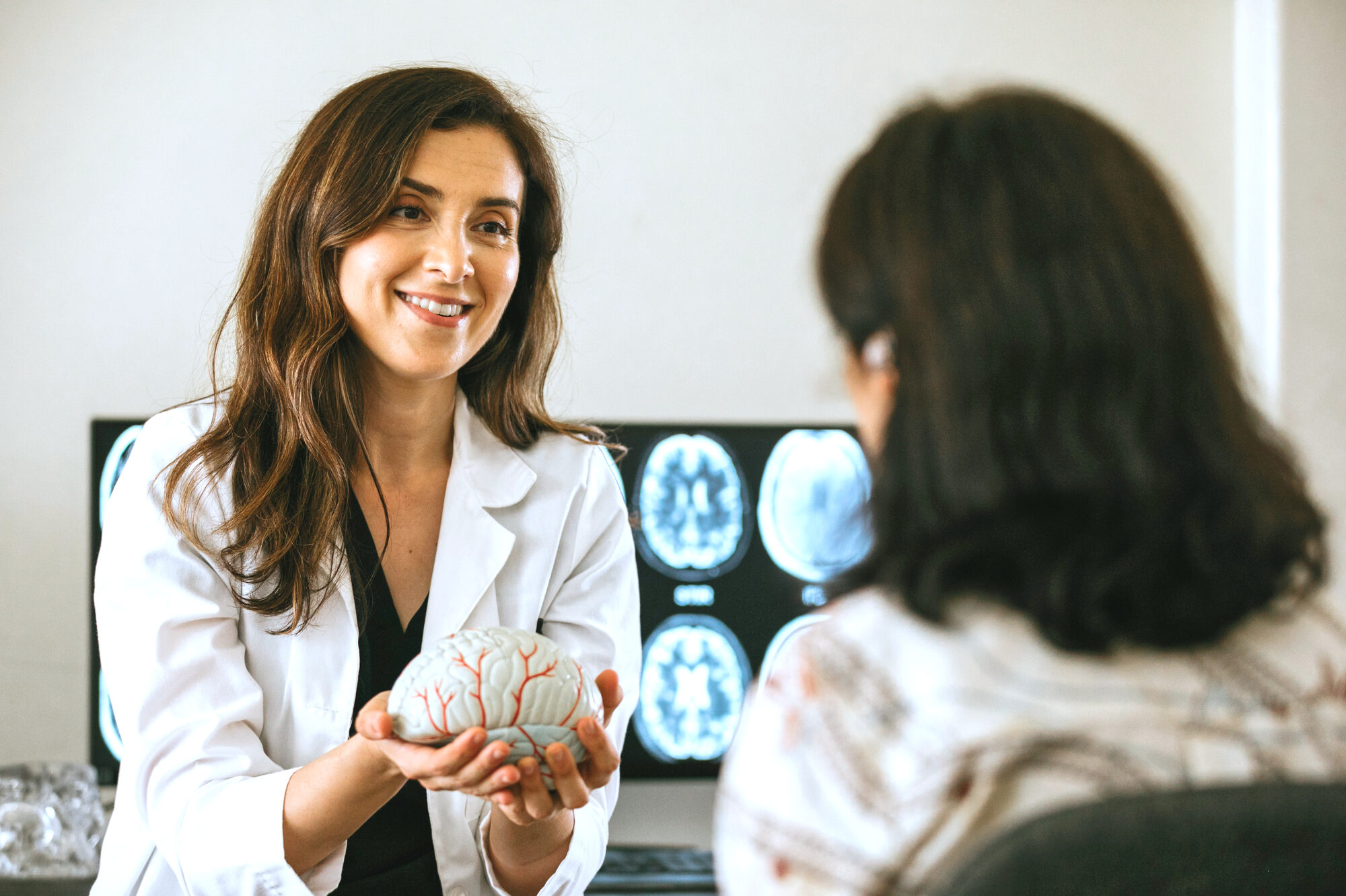Neurologist explaining a brain model to a patient